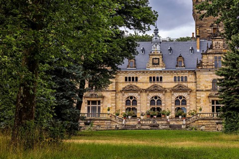 Historic castle surrounded by lush nature and cloudy skies, The Hummelshain hunting lodge in