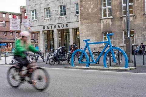 Bicycle parking spaces, with so-called leaning bars and a large blue bicycle silhouette, to make