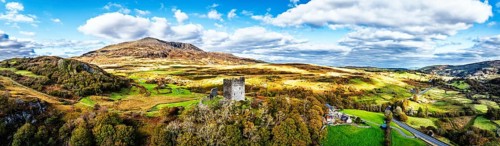 Autumn colours over Castell Dolwyddelan and Eryri Mountains from a drone, Snowdonia, Conwy County