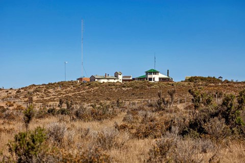 A secluded building on a hill with vegetation under a blue sky, The countryside of Peninsula Valdes