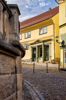 Yellow historic building on a paved street with classic architecture, The old town of Arnstadt in