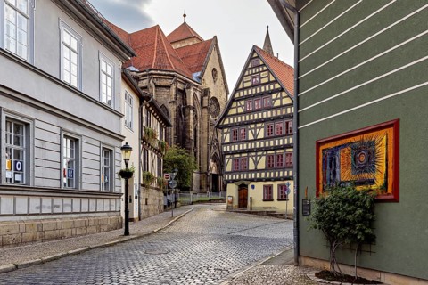 Atmospheric alley with half-timbered houses, church in the background and evening lighting, the old