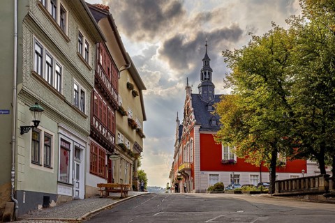 Street with historic facades and church tower under a dramatic sky in the old town, The old town of