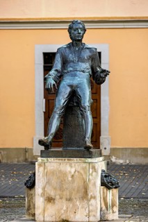 Bronze statue of a man in front of a façade in autumn, Johann Sebastian Bach monument in the old