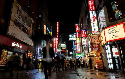 Busy pedestrian zone with many shopping centers and stores, illuminated with lots of neon signs at