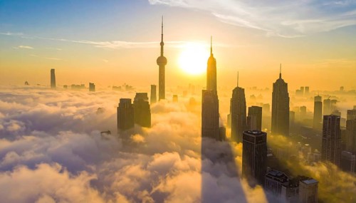City scape emerging from a dense enveloping fog in sunrise and skyscrapers piercing the haze, big