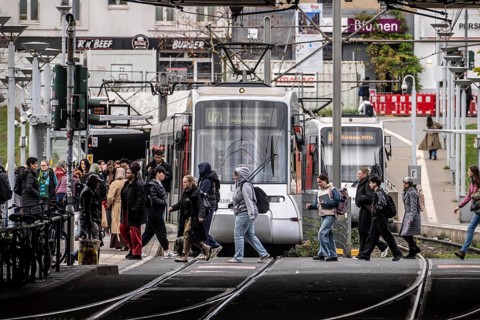 Pedestrians cross the tram tracks, at Düsseldorf-Bilk station, junction of S-Bahn, subway, tram,