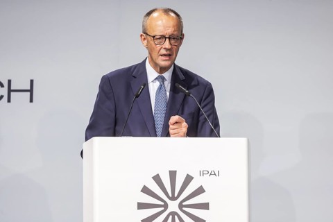 Federal Chancellor Friedrich Merz (CDU) . Portrait at the lectern with free text space.