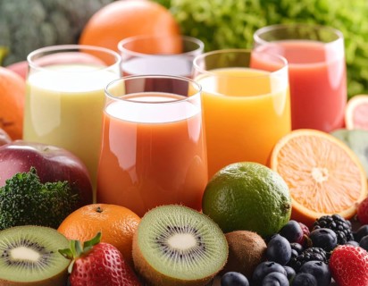 Fresh fruit juices in glasses, surrounded by colorful fruits, showcasing healthy drinking and