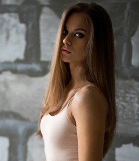 Gorgeous sexy blonde in beige body posing by a gray stone wall shot in new studio