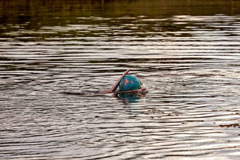 A ball floats on a calm water surface with gentle reflections of the surroundings, The Bolivian