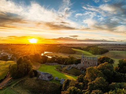 Sunset over Norham Castle and River Tweed from a drone, Norham, Northumberland, England, United