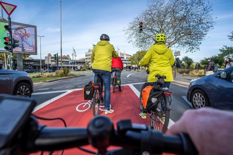 Riding a bike in a bike lane, marked in red to attract the attention of motorists, between 2 lanes,