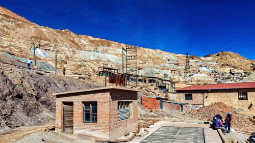 Small buildings in a dry, desert-like mining area with people, The silver mines of Potosi Bolivia