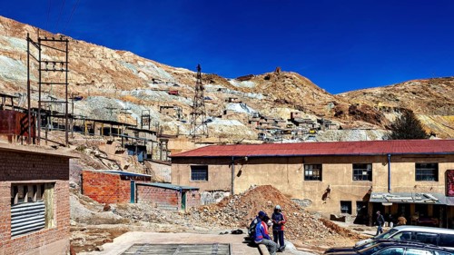 Working area of a mine with people and vehicles in a barren area, The silver mines of Potosi