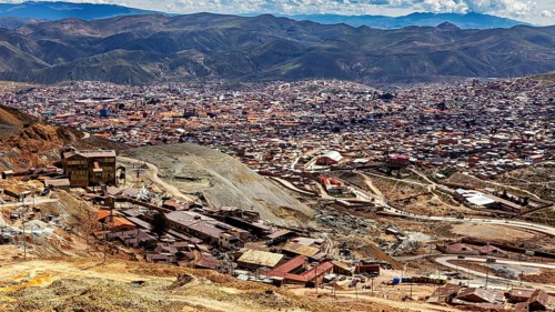 Panoramic view of a wide urban landscape surrounded by majestic mountains and clouds, The silver