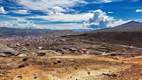 Large cityscape between hills under a dramatically cloudy sky with a wide view, view from Silver