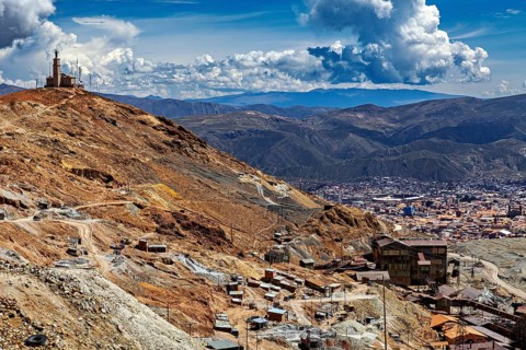 Sweeping views over a city in the middle of a mountain landscape under dramatic clouds, The silver