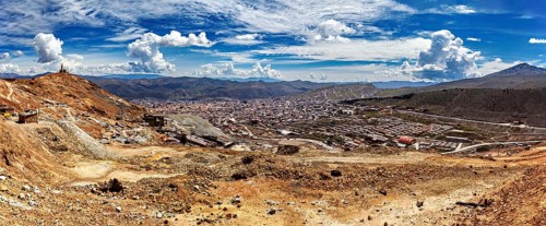 Panoramic view of a vast landscape with mountains and a city under a cloudy sky, view from Silver