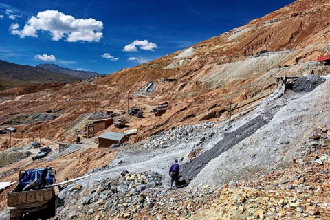 A worker moves on a stony hill with a wide view over the landscape, The silver mines of Potosi
