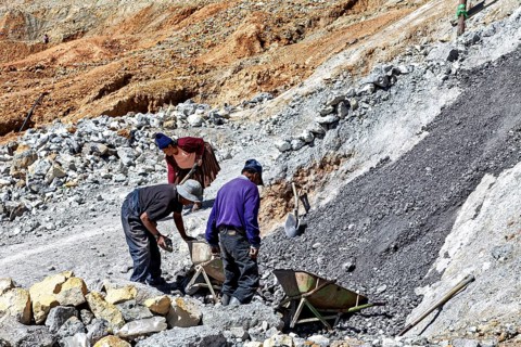 Labourers work together while moving gravel on a rough hillside, The silver mines of Potosi Bolivia