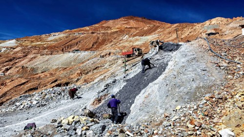 Scene of labourers working on a steep, stony slope under a blue sky, The silver mines of Potosi