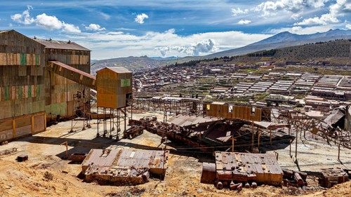 Industrial building in the foreground with sweeping views over a valley and mountains, The silver
