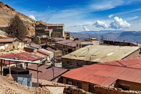 View of roofs and abandoned mine buildings with hills in the background, The silver mines of Potosi