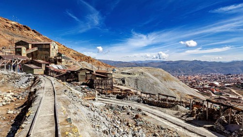 View of abandoned mine buildings and railway tracks in a hilly landscape, The silver mines of