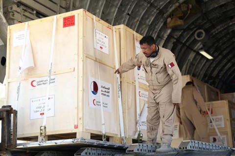 Members of the Qatari Air Force unload humanitarian aid supplies from a transport aircraft at