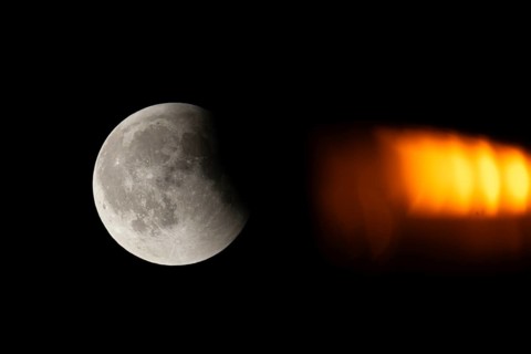 After a total lunar eclipse, the moon appears shortly after its rise in the evening sky as a