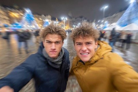 Two men in fighting pose on a rainy street at night, surrounded by lights, symbolic image for