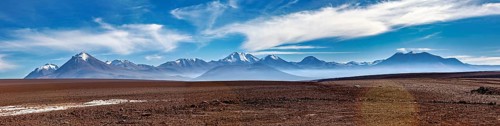 Long mountain range under a clear, cloudy sky in a vast landscape, The landscape with the volcanoes