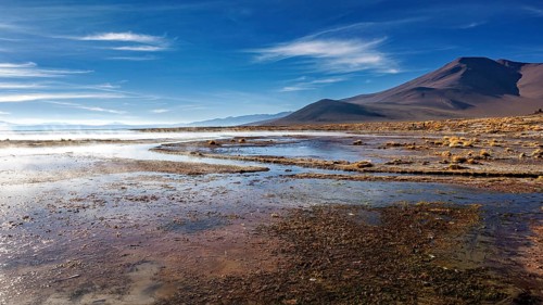 Vast steppe landscape with mountains in the background under a clear sky, The thermal springs of