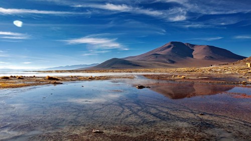 Majestic mountains reflected in calm waters under clear skies, The thermal springs of Polques in