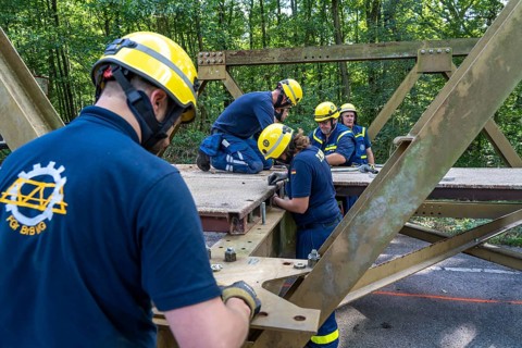Construction of a temporary bridge over a slipped road crossing a stream, by the bridge