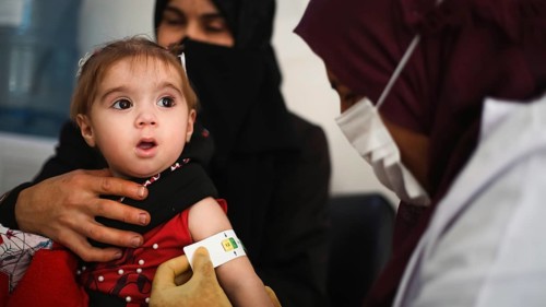 A doctor examines children's malnutrition inside a refugee camp. Malnutrition was measured using a
