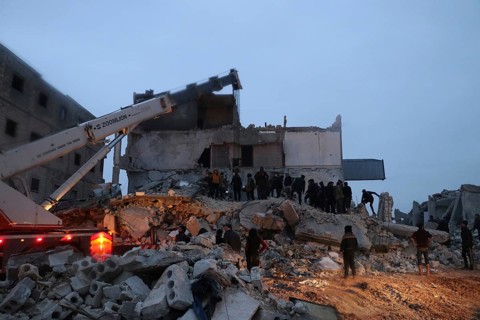 Civil defense teams attempt to rescue civilians trapped under the rubble after a powerful