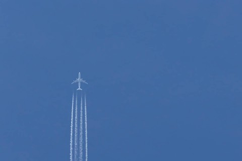 Airbus A340-300 jet aircraft of Lufthansa airlines in flight in a blue sky with vapour trails or