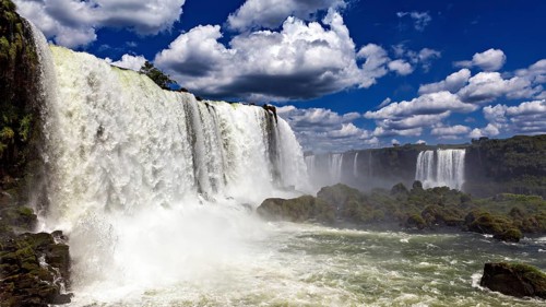 Towering waterfalls flow powerfully under dramatic skies, The Iguazu Falls between Argentina and