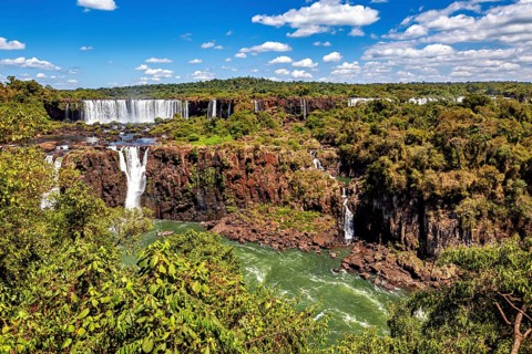 Impressive waterfalls with lush natural scenery under a bright blue sky, The Iguazu Falls between