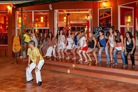 Group of people following a dance leader on a stage, samba dancers to entertain tourists at the