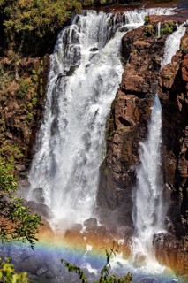 Impressive waterfall with rainbow in front of a rocky wall, The Iguazu Falls between Argentina and