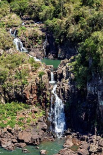 Waterfall plunging into a rocky landscape of lush greenery, The Iguazu Falls between Argentina and