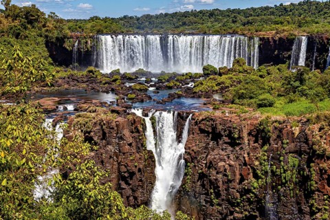 Spectacular waterfall flows over rocky cliffs in lush natural surroundings, The Iguazu Falls