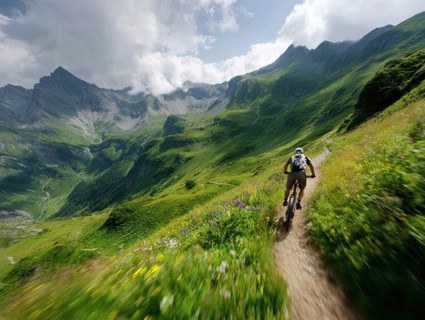 A single mountain biker quickly rides a trail in the high mountains, motion blur, AI generated, AI