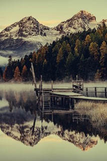 Lake Staz near Sankt Moritz in the Engadin in Switzerland. Morning atmosphere with fog in autumn.