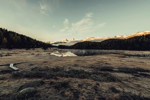 Lake Staz near Sankt Moritz in the Engadin in Switzerland. Morning atmosphere with fog in autumn.