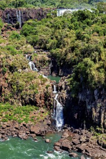 Small waterfall flows through a rocky gorge surrounded by dense vegetation, The Iguazu Falls