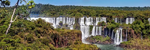 Scenic waterfalls and dense vegetation on a clear day, The Iguazu Falls between Argentina and